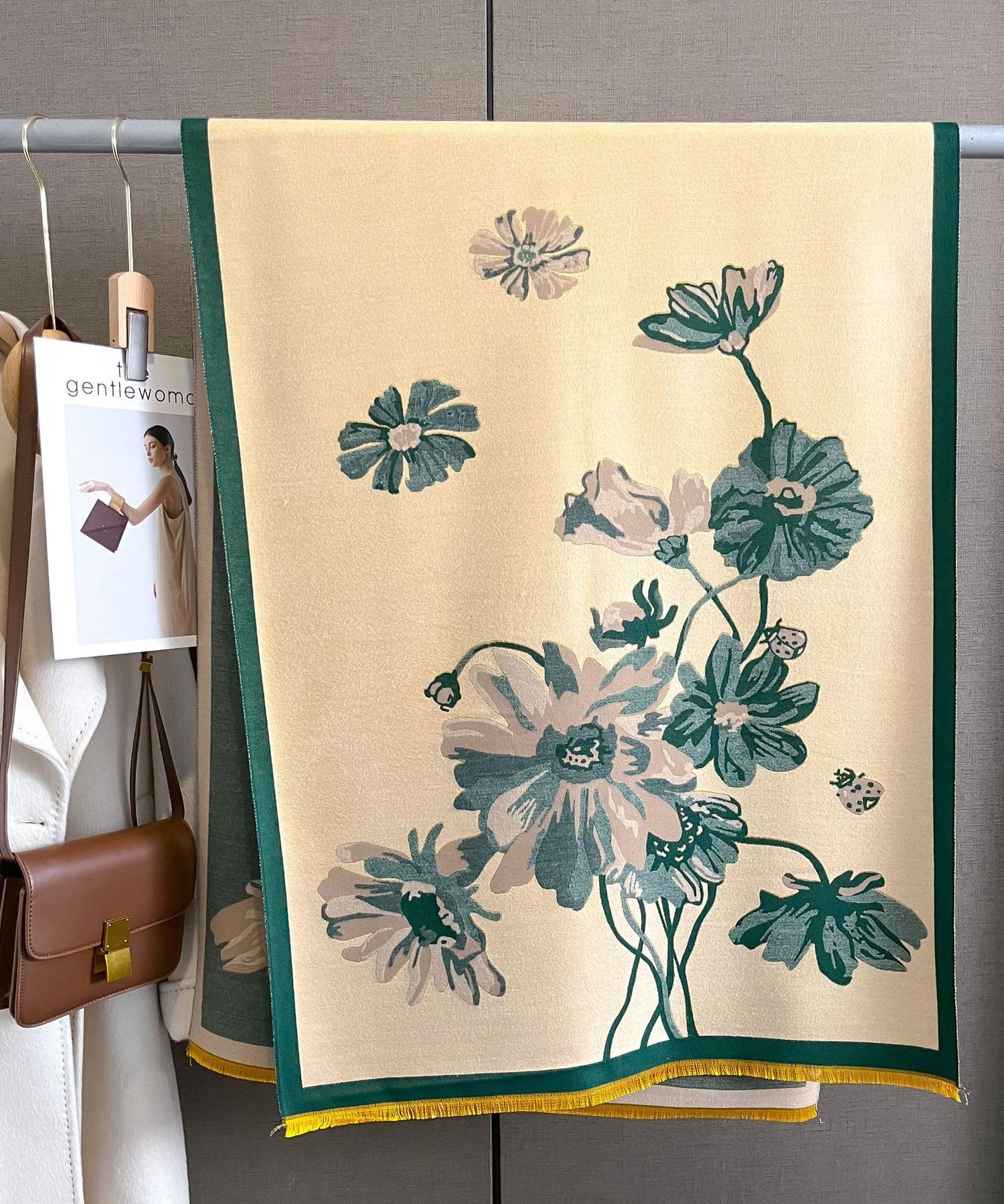 Floral-patterned towel hanging on a rack with a visible brand tag.