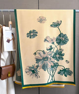 Floral-patterned towel hanging on a rack with a visible brand tag.